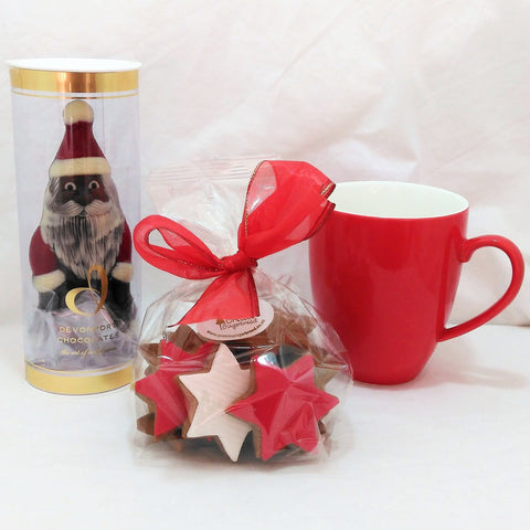 Christmas gift with chocolate Santa, red coffee mug and bag of gingerbread stars